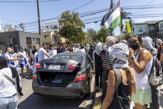 Los Angeles, CA - June 23: Pro-Palestine protester gets in car that is being swarmed by Pro-Israel protesters near Adas Torah on 9040 block of West Pico Boulevard on Sunday, June 23, 2024 in Los Angeles, CA. (Zoe Cranfill / Los Angeles Times)