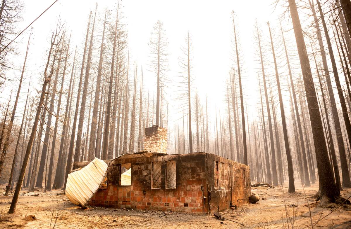 The remains of a home smolders during a wildfire