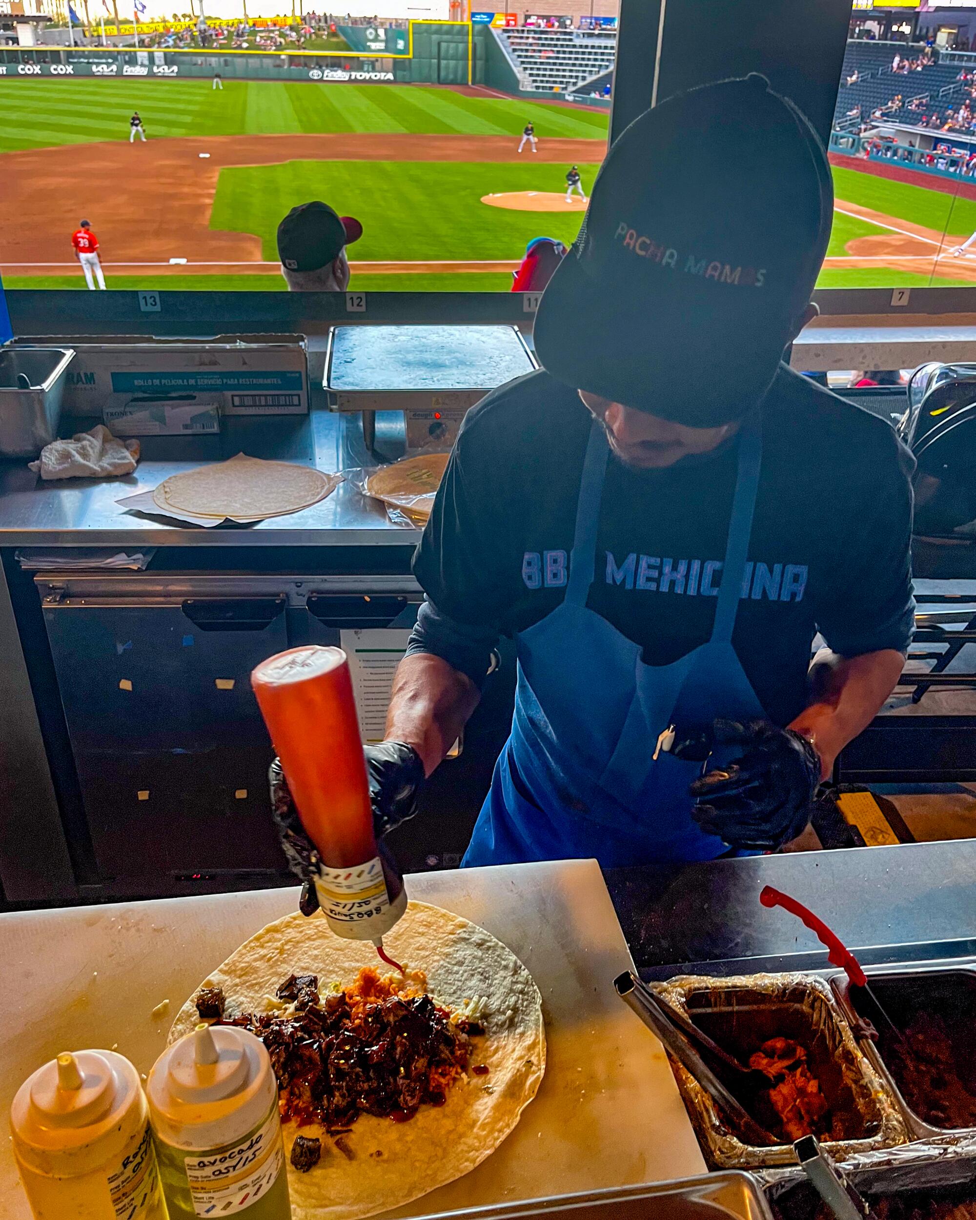 A worker squirt salsa on a burrito-in-the-making at Las Vegas Ballpark