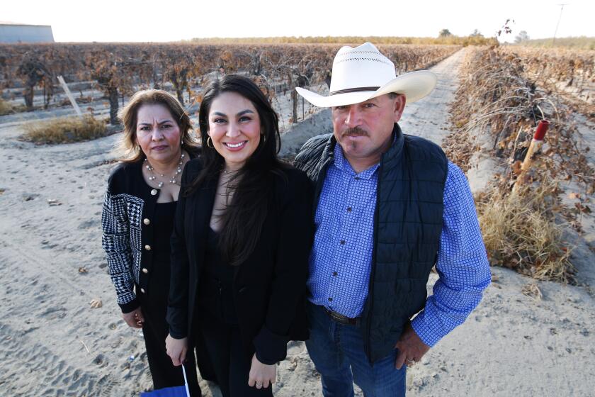 Jessenia Nunez, center, is shown with her mom, Vilma and father Rafael in a grape field near her home in Mendota