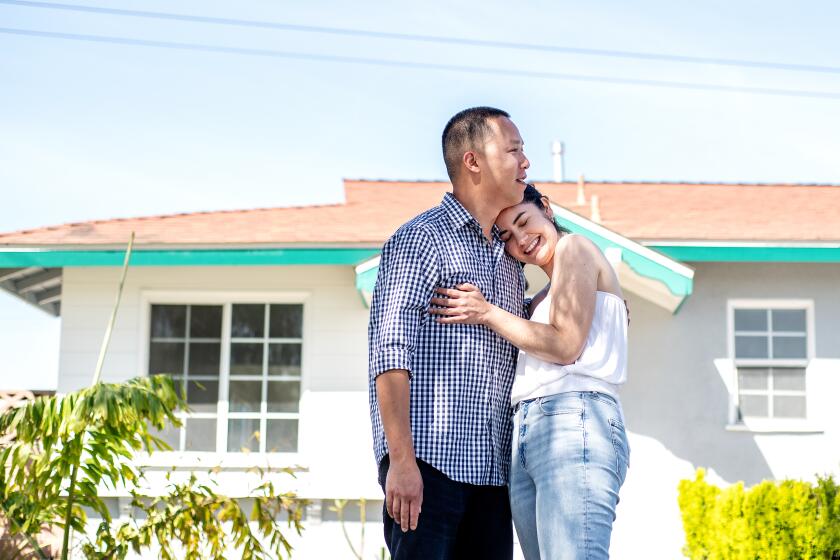 LONG BEACH, CA - MARCH 22: Portrait of first-time homebuyers Sarah Gonzalez and John Tran outside their home in North Long Beach on Tuesday, March 22, 2022. After saving for over 8 years for a down payment, the couple was able purchased the home in December of 2021. (Mariah Tauger / Los Angeles Times)