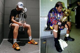 Caitin Clark recreates a 2001 photo of Kobe Bryant with a trophy. Both players have their heads down and serious expressions.