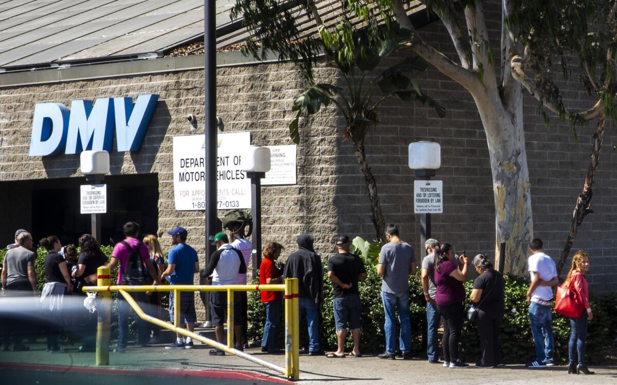A line of people outside a DMV office 