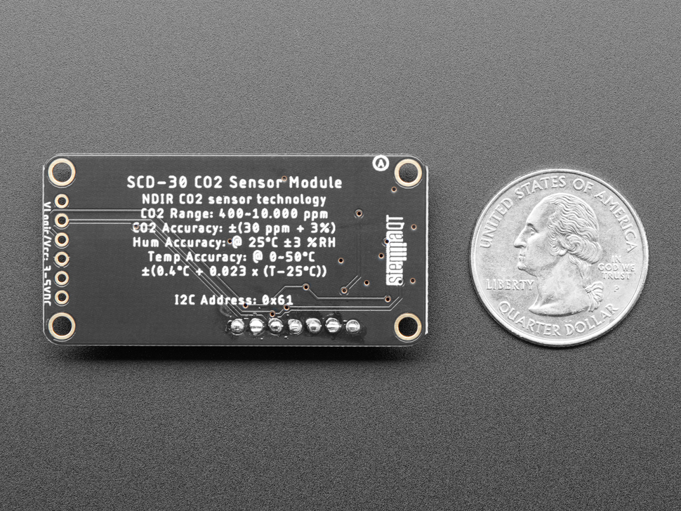 Back view of a Adafruit SCD-30 - NDIR CO2 Temperature and Humidity Sensor next to US quarter for scale. 