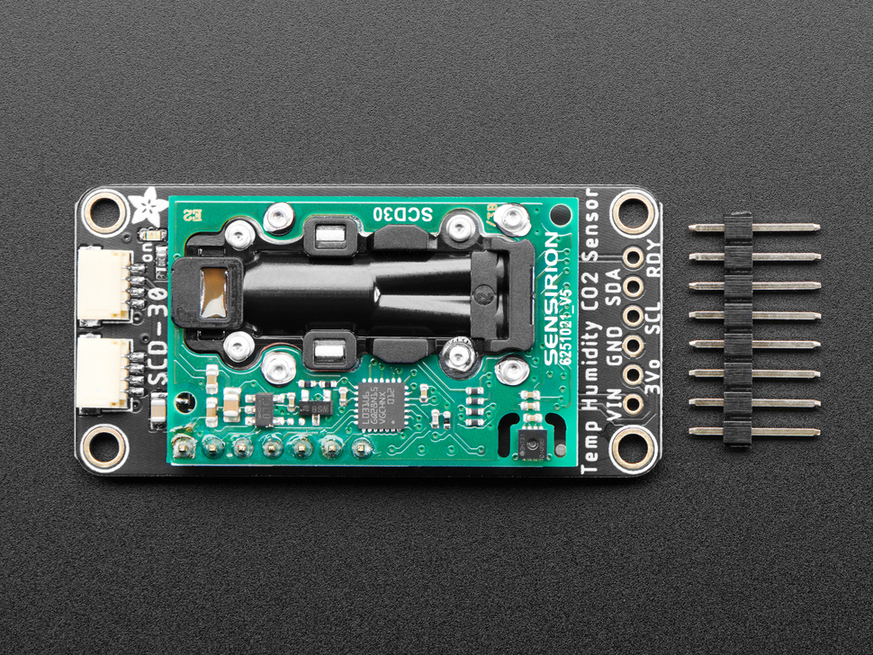 Adafruit SCD-30 - NDIR CO2 Temperature and Humidity Sensor with tan STEMMA QT connectors next to a 6-pin header. 