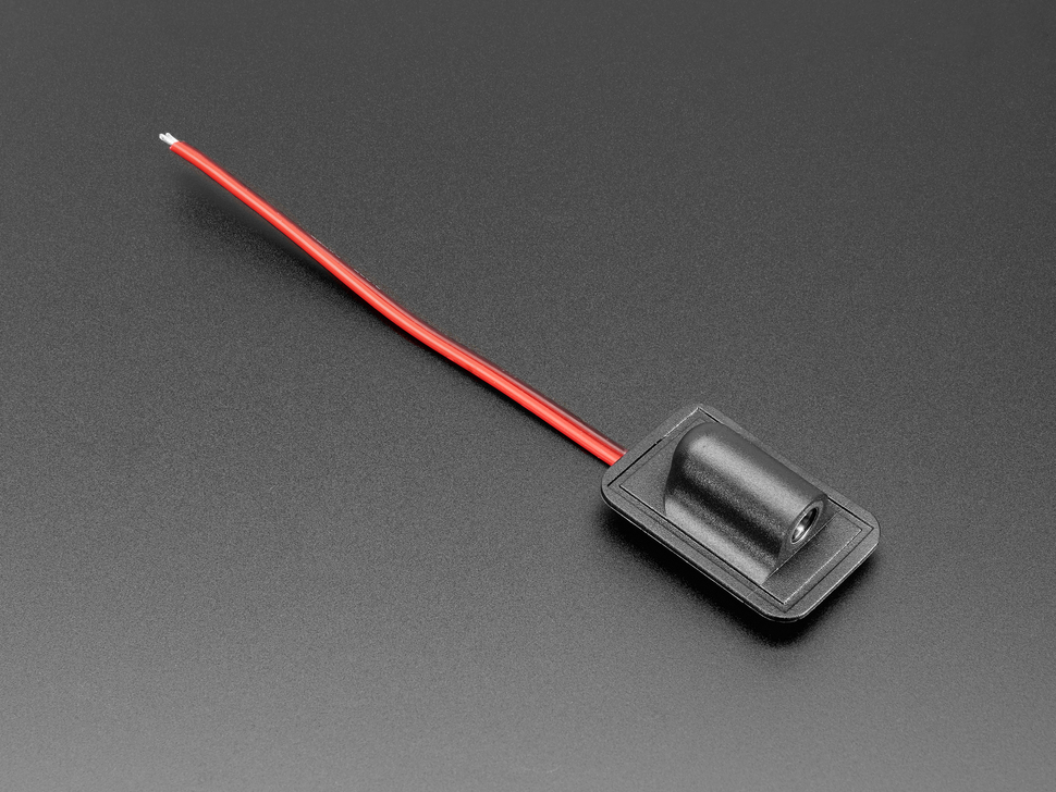 Angled shot of sewable DC jack connector with black and red wires.