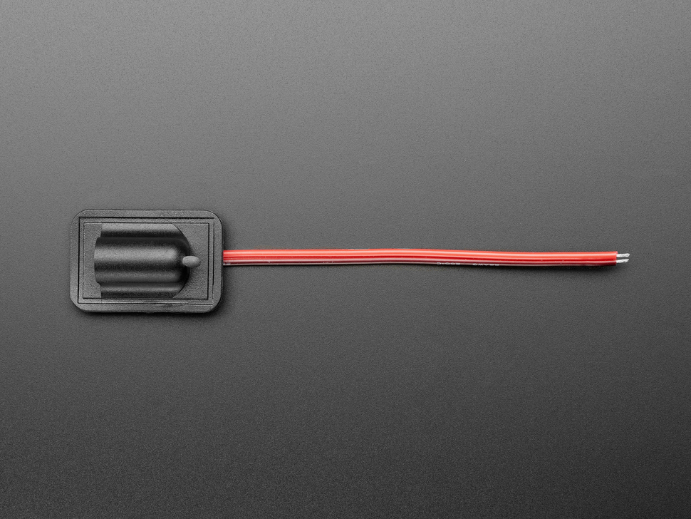 Overhead shot of sewable DC jack connector with black and red wires.