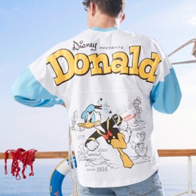 Young man standing away from the camera on a boat & wearing a light blue and white Donald Duck Spirit Jersey with text “Disney Presents Donald Since 1934”.