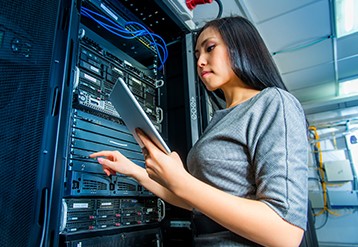 Woman in a computer center holding a tablet.