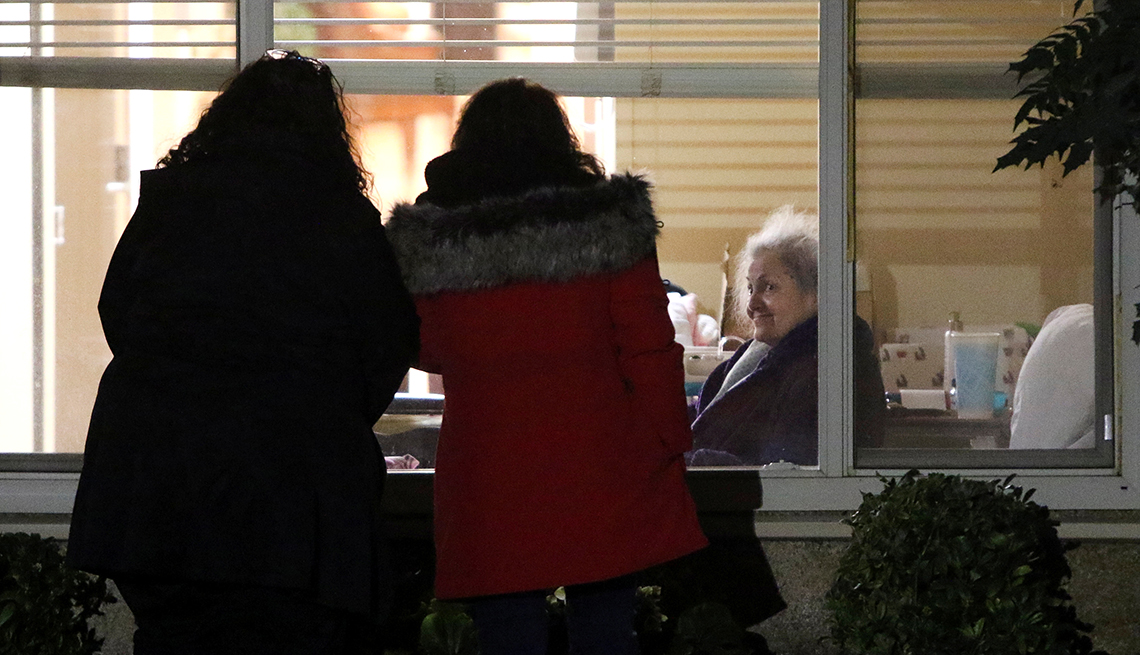 two women look at another woman in a hospital bed