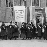 Philadelphia women's suffrage group at headquarters. Hold banner that reads "Mr. President How Long Must Women Wait for Liberty." (women's suffrage)