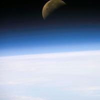 A quarter moon is visible in this oblique view of Earth's horizon and airglow, recorded with a digital still camera on the final mission of the Space Shuttle Columbia.