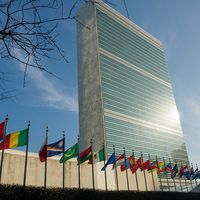 Secretariat Building at United Nations Headquarters with Members States' flags flying in the foreground, United Nations Headquarters, New York City, New York. (photo dated 2017)