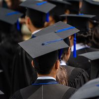 College graduation. University graduates in caps and gowns.