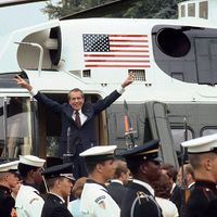 President Richard M. Nixon smiles and gives the victory sign as he boards the White House helicopter after his resignation on August 9, 1974 in Washington, D.C.