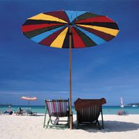 Deck chairs under a beach umbrella.