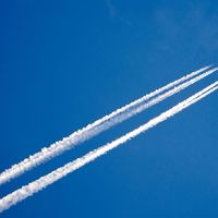 Airplane in the sky with a trace of steam contrail.