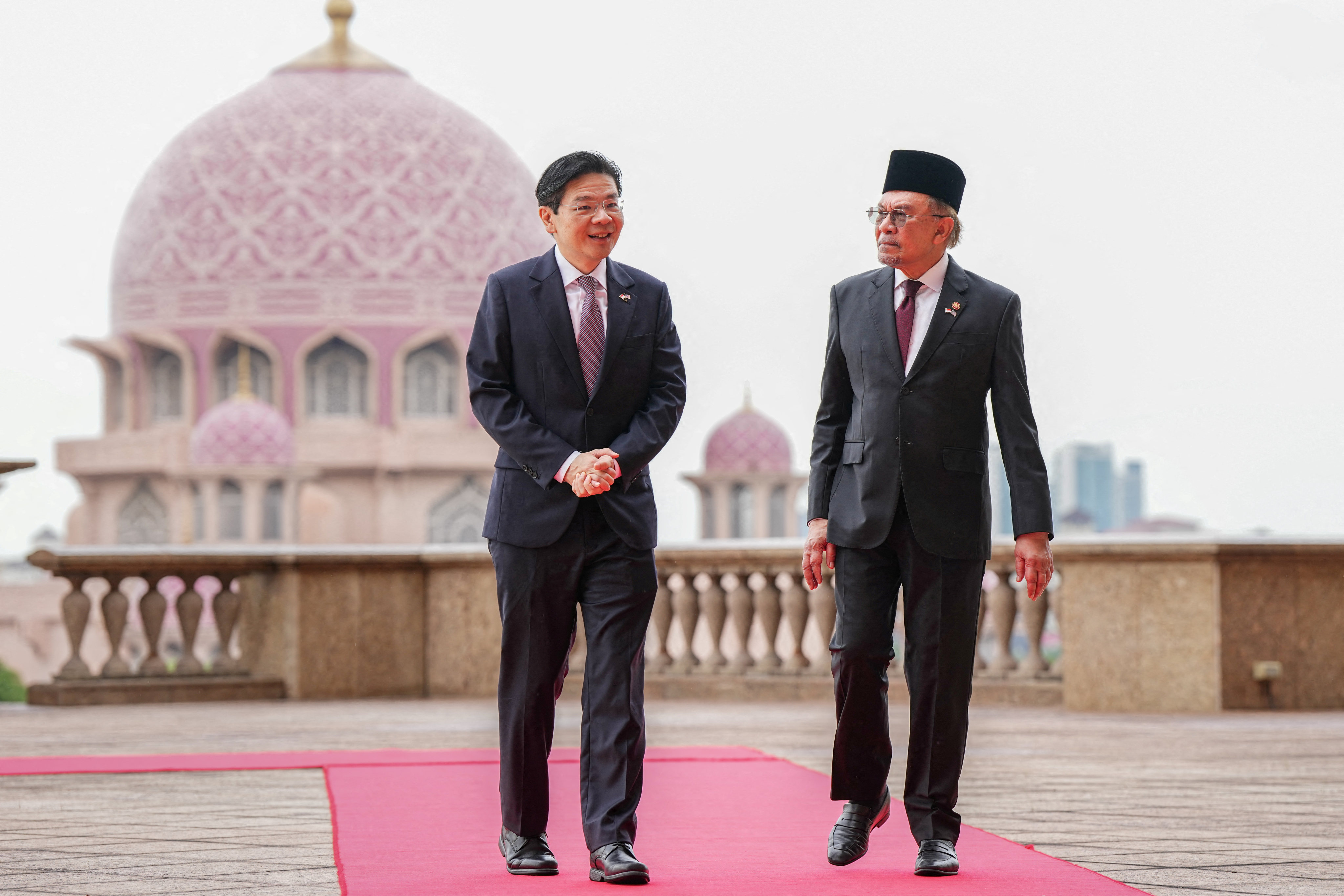 Singapore’s Prime Minister Lawrence Wong walks with his Malaysian counterpart Anwar Ibrahim with the background of Putra Mosque in Putrajaya, Malaysia, on Tuesday. Photo: Pool via Reuters