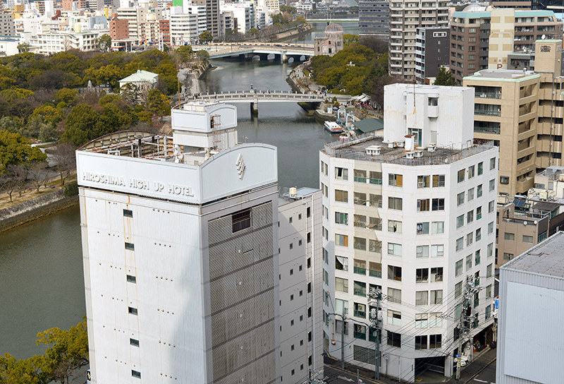 （１１）毎日新聞広島支局跡周辺（手前右）から北西を撮影。左奥は平和記念公園。木々に囲まれた建物はレストハウス（旧燃料会館）、中央奥には原爆ドーム（旧広島県産業奨励館）が見える＝広島市中区で２０１７年２月６日、山田尚弘撮影