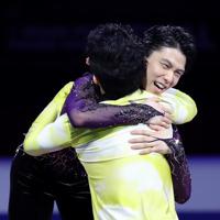 表彰式で米国のネーサン・チェンと抱き合う羽生結弦＝イタリア・トリノのパラベラ競技場で２０１９年１２月７日、貝塚太一撮影