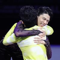 表彰式で米国のネーサン・チェンと抱き合う羽生結弦＝イタリア・トリノのパラベラ競技場で2019年12月7日、貝塚太一撮影