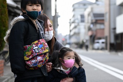 被災した自宅跡の前で、当時の体験を次男の想真ちゃん（左）と次女の心愛ちゃん（右）に語りかける茂森美香さん＝神戸市兵庫区で2021年1月17日、山田尚弘撮影