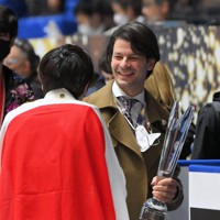 GPシリーズNHK杯で宇野昌磨（手前）が優勝し、渡されたトロフィーを手に笑顔で話すステファン・ランビエルコーチ＝東京・国立代々木競技場で２０２１年１１月１３日、手塚耕一郎撮影