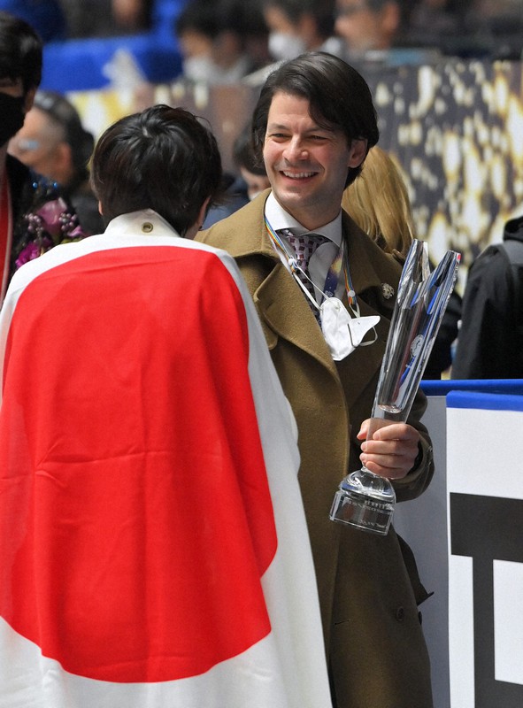 GPシリーズNHK杯で宇野昌磨（手前）が優勝し、渡されたトロフィーを手に笑顔で話すステファン・ランビエルコーチ＝東京・国立代々木競技場で２０２１年１１月１３日、手塚耕一郎撮影