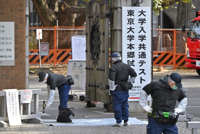 大学入学共通テストの試験会場だった東大前の路上で受験生らが切りつけられ、現場付近を調べる警視庁の捜査員ら＝東京都文京区で2022年1月15日午前、手塚耕一郎撮影