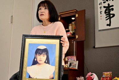 青木恵子さんは約25年前の火災で亡くなっためぐみさんの遺影を手に、大阪地裁判決への思いを語った＝大阪市内で2022年3月5日、山田尚弘撮影