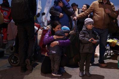 ポーランド入国後間もなく、ウクライナ難民を乗せ市街地へ向かうバス乗り場で泣く子を抱きしめる女性＝ポーランド南東部メディカで2022年3月24日午後6時12分、小出洋平撮影