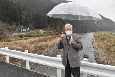 黒い雨の援護対象区域を分ける境界線となった川にかかる橋に立ち、「線引きのおかしさを突くところから運動は始まった」と話す武田知明さん＝広島市佐伯区湯来町で2022年3月23日午後2時55分、小山美砂撮影