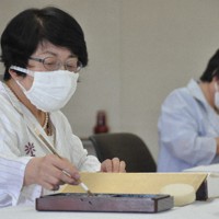 原爆死没者名簿に記帳する中本信子さん（左）と池亀和子さん＝広島市中区の広島市役所で、中村清雅撮影