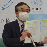 被爆体験者訴訟の最高裁判決を手に、後藤厚労相の答弁は誤りだと批判する長崎県保険医協会の本田孝也会長＝長崎市で2022年6月6日午後1時8分、樋口岳大撮影