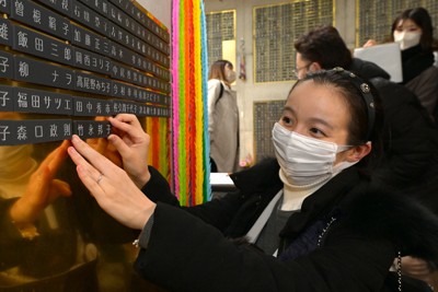 祖母の竹永邦子さんの銘板を設置する赤阪美智子さん＝神戸市中央区で2022年12月17日午後1時58分（代表撮影）