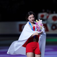 表彰式を終え、国旗を背負いリンクを一周する優勝した坂本花織＝さいたまスーパーアリーナで2023年3月24日、吉田航太撮影