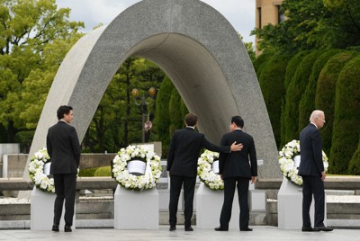 原爆慰霊碑の献花を終え、岸田文雄首相（右から2人目）の背中に手をやるフランスのエマニュエル・マクロン大統領（同3人目）。左端はカナダのジャスティン・トルドー首相、右端は米国のジョー・バイデン大統領＝広島市中区で2023年5月19日（外務省提供）