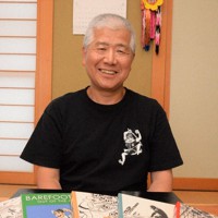 英語版の漫画と「はだしのゲンをひろめる会」の神田順一事務局長＝金沢市内で2023年7月6日午後3時2分、阿部弘賢撮影