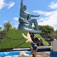 台風6号の接近に伴い、平和祈念式典会場の撤去作業にあたる作業員たち＝長崎市松山町の平和公園で2023年8月7日午前10時6分、川島一起撮影