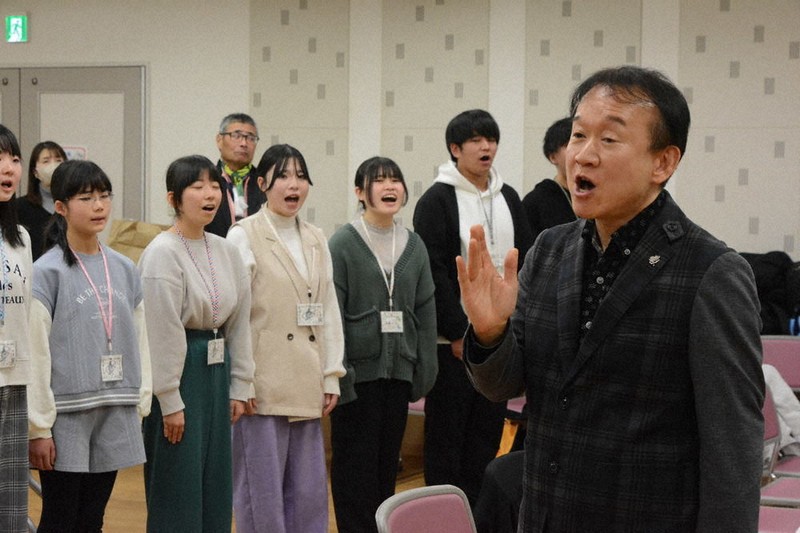 神戸の学生たちとの交流のため訪れた「福島しあわせ運べるように合唱団」の指揮をしながら「しあわせ運べるように」を歌う神戸親和大の臼井真准教授（右）＝神戸市北区で2023年12月27日午前11時51分、山本康介撮影