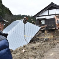 安否不明の垣地英次さんの捜索現場でぼうぜんと立ち尽くす兄弘明さん＝石川県輪島市市ノ瀬町で2024年1月20日午前11時16分、阿部絢美撮影