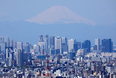 都心のビル群の向こうに見える富士山＝東京都内で2020年4月、本社ヘリから宮武祐希撮影