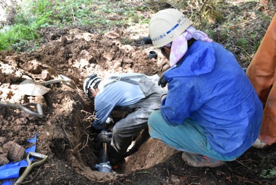 水道の復旧工事で、応援に入った金沢市企業局の委託を受けて、漏水していた水道管の復旧工事をする事業者。山あいの地区で重機が入らないため手作業で工事をしていた＝石川県能登町で2024年4月26日午前9時55分、砂押健太撮影