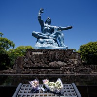 平和公園に立つ、花が手向けられた平和祈念像＝長崎市で、吉田航太撮影