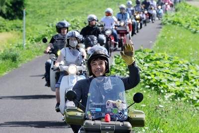 空知川の河川敷を「スーパーカブ」に乗って走る「カブ主」ら＝北海道富良野市で2022年8月11日、貝塚太一撮影