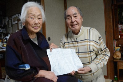 初めて記した体験記を手にする栗田弥生さん（左）と幼なじみの山本誠一さん＝長崎市茂木町で2024年5月8日午後1時46分、尾形有菜撮影