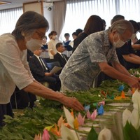 花と折り鶴を手向ける参列者＝さいたま市浦和区のさいたま共済会館で2024年7月28日、萩原佳孝撮影