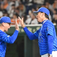 【巨人－DeNA】試合に勝利し、選手たちとハイタッチするDeNAの三浦大輔監督（右）＝東京ドームで2024年10月18日、三浦研吾撮影