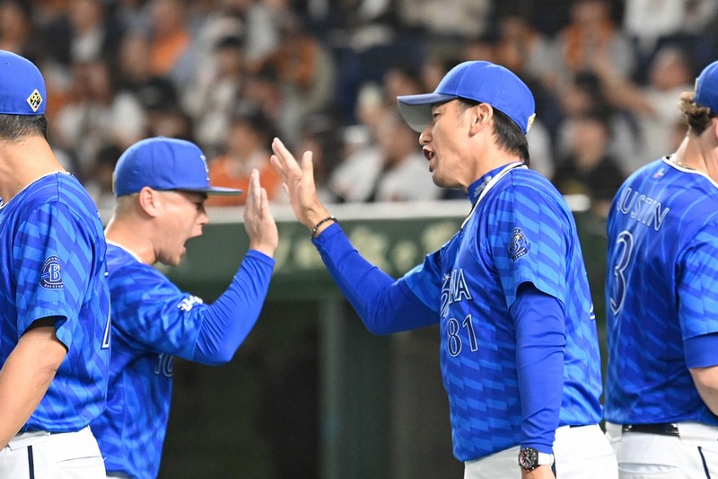 【巨人－DeNA】試合に勝利し、選手たちとハイタッチするDeNAの三浦大輔監督（右）＝東京ドームで2024年10月18日、三浦研吾撮影