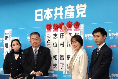 開票状況を受け、当選確実のバラつけをする共産党の田村智子委員長（右から2人目）＝東京都渋谷区で27日午後9時過ぎ、加藤明子撮影